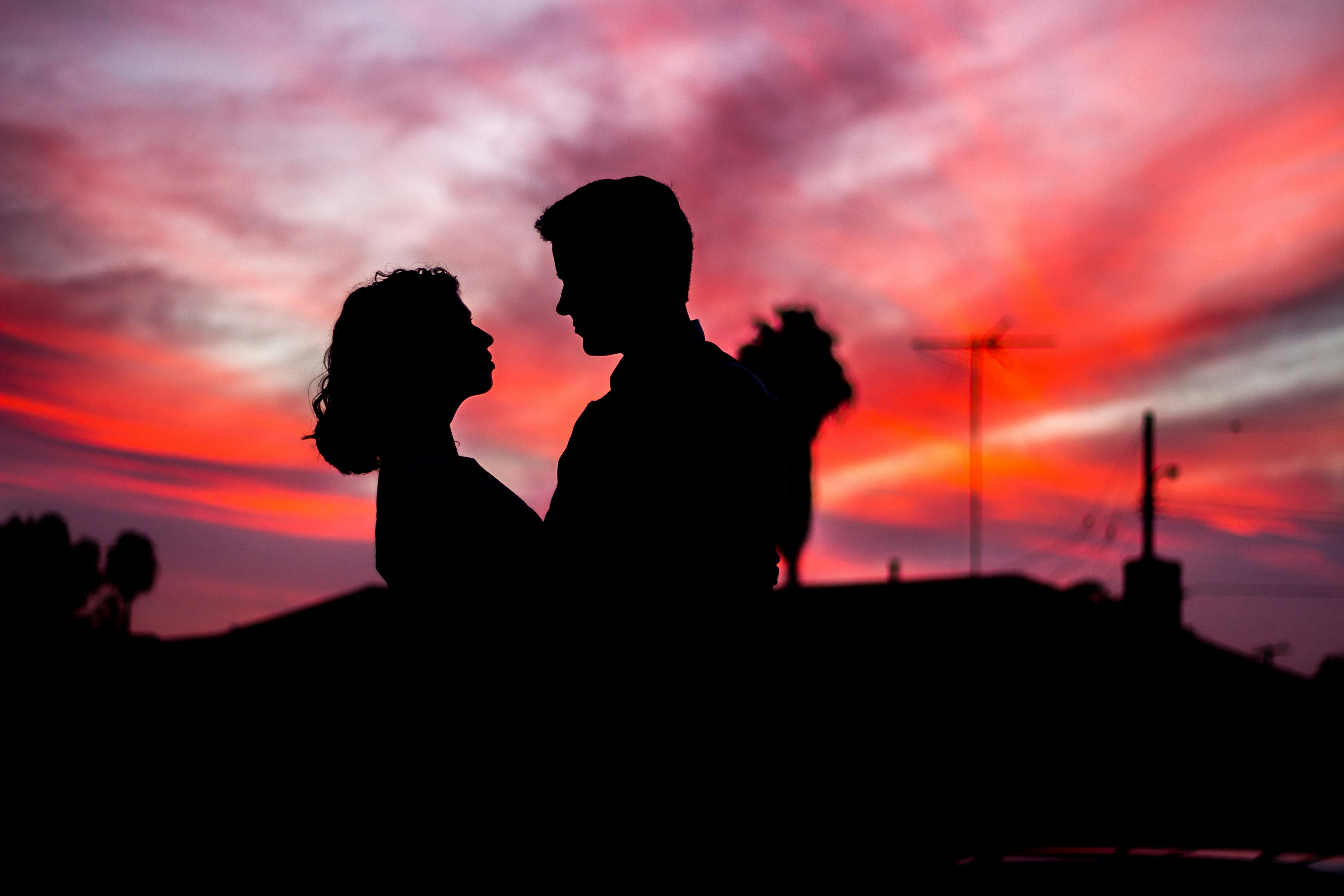 A couple embracing in front of a sunset