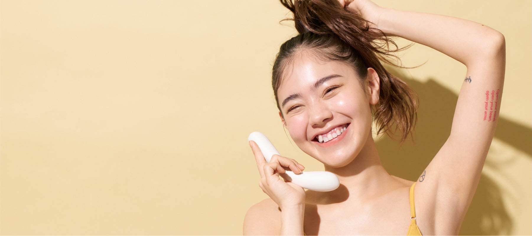 Woman holding a white iroha mai TSURU vibrator against a yellow background